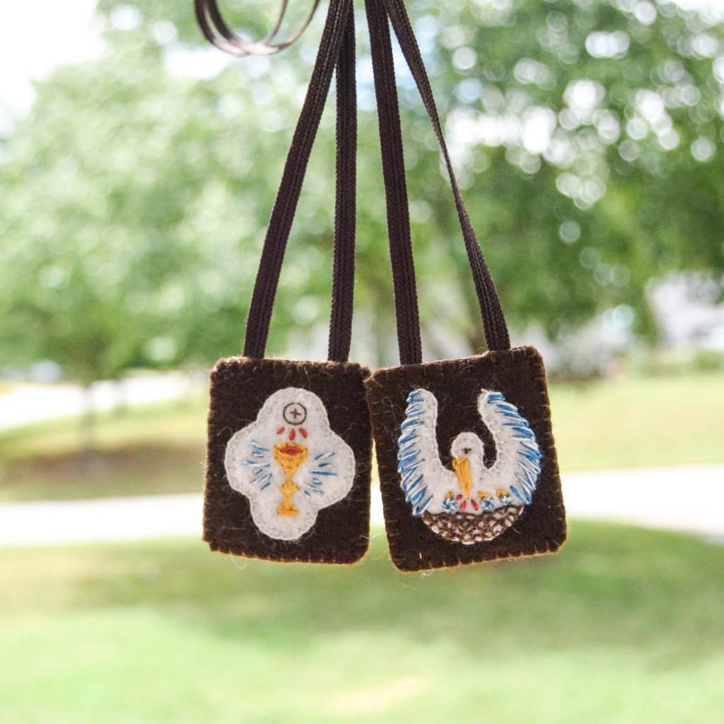 Pelican in Piety and Chalice and Host embroidered on Brown scapular in front of green background