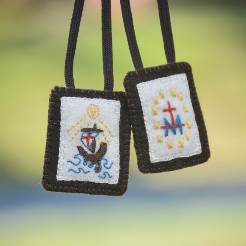 Stella Maris Scapular: embroidered with boat on the waves, star, rays, and M for Mary, in front of faded green background
